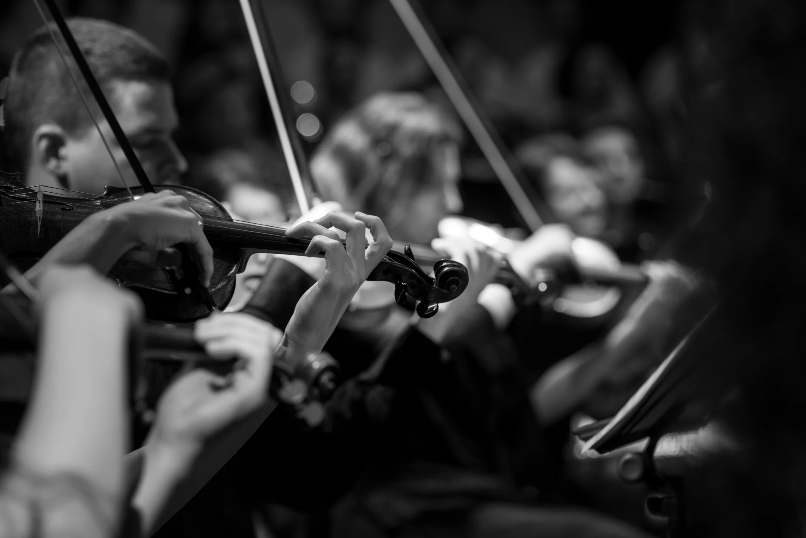 Student orchestra performing on stage — group performance tour for high school and college musicians